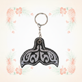 Whale tail embroidered keychain on a pale tropical background without a shadow