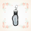 Flip flop keychain on a pale tropical background without a shadow