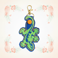 Gecko filled keychain on a pale tropical background without a shadow