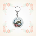 Turtle Wave Riding round keychain on pale pineapple-and-palm background